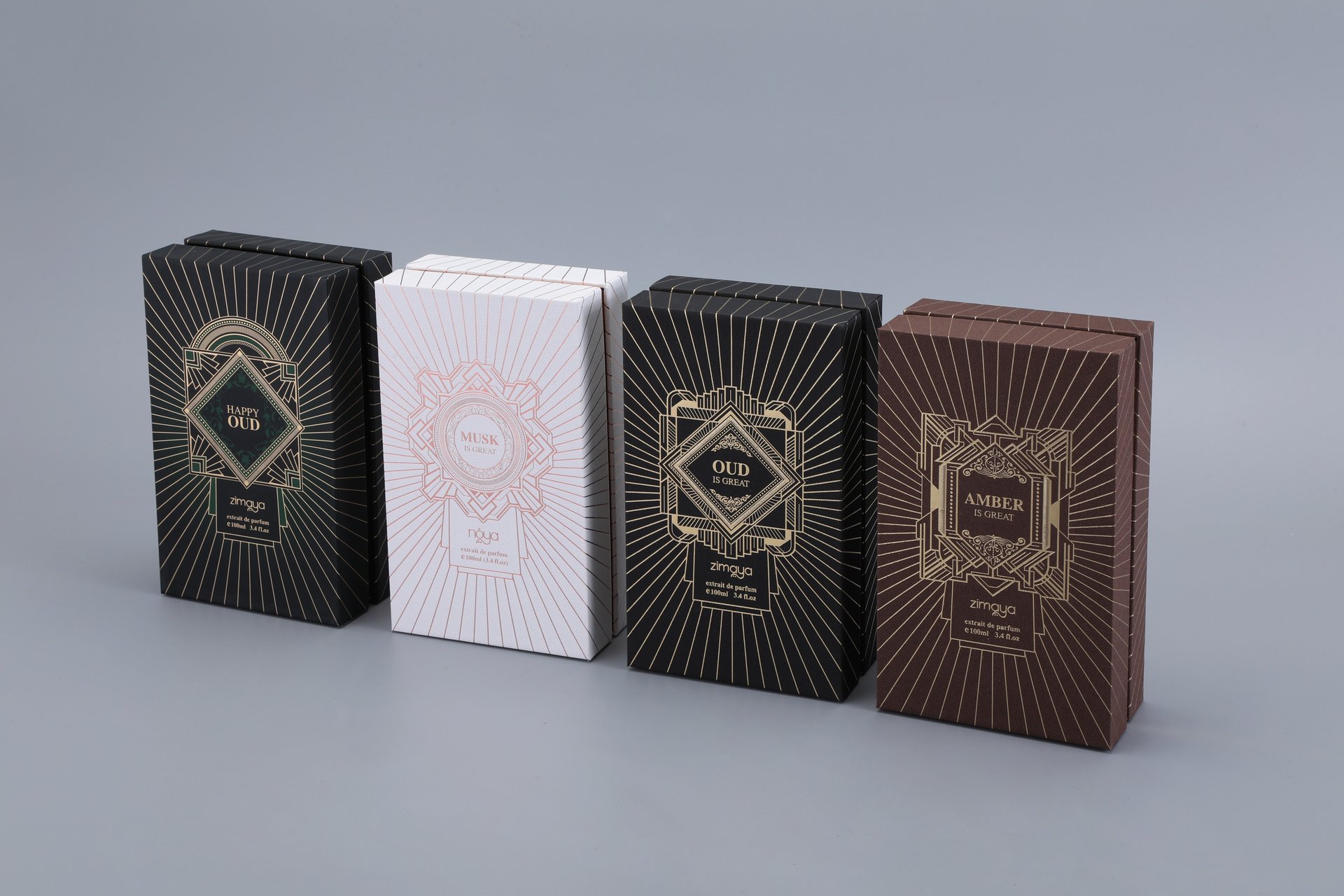 This image showcases our custom box packaging featuring four soap boxes with intricate designs. The boxes, each distinguished by unique patterns, represent a variety of scents including Musk, Amber, White Oud, and Oud Royale. The boxes are arranged in a row against a plain background.