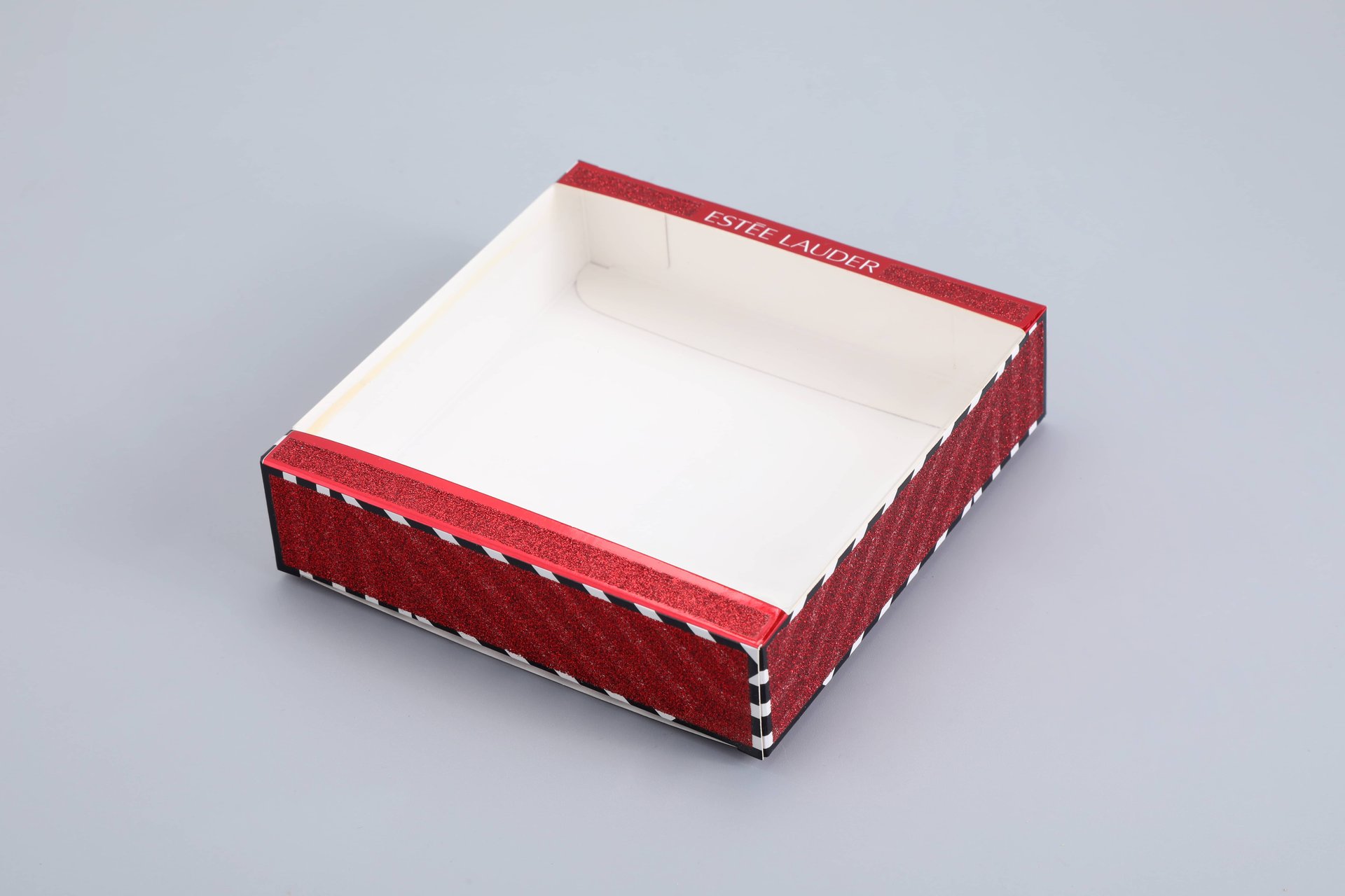 "This image showcases our custom packaging solution: a red and white box with decorative black and white edges, viewed from above. The design highlights our expertise in creating visually appealing and functional packaging options tailored to the client's specifications.