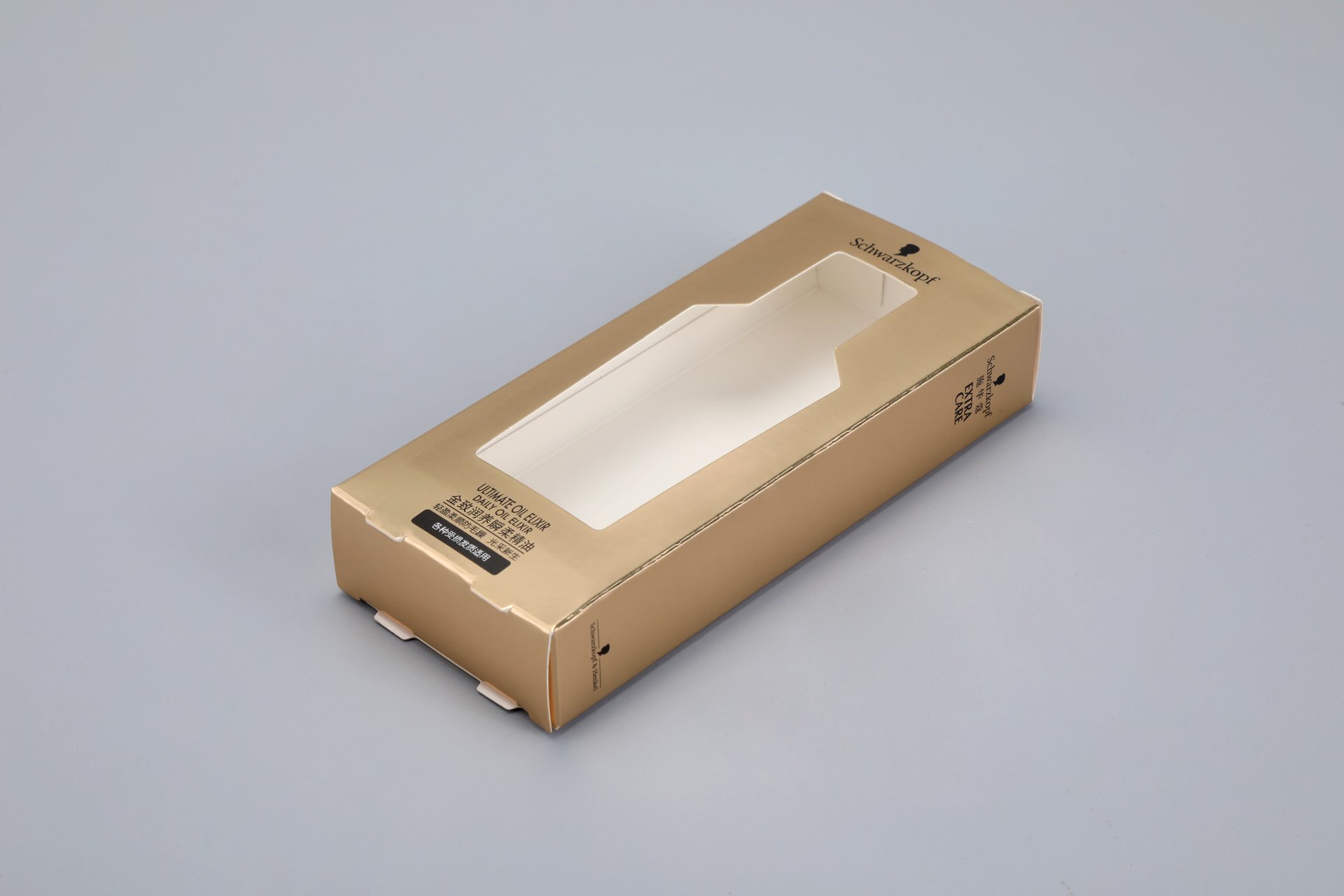 "Our custom packaging solution is a premium gold cardboard box featuring a transparent window, designed to showcase the contents within. The sophisticated design is set against a neutral gray background, emphasizing the elegance and quality of our packaging without displaying any text on the surface.