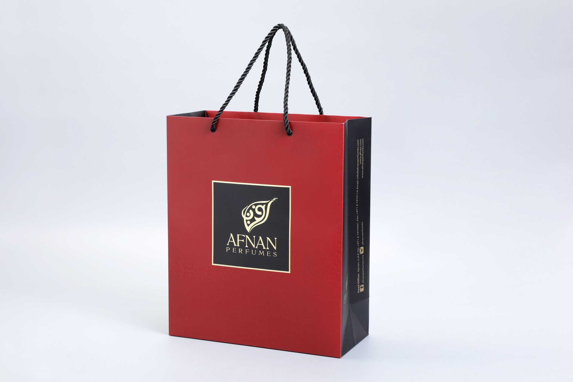 We are a manufacturer of custom box packaging. This image showcases one of our packaging solutions: a customized box featuring a rope handle, designed in a sleek red and black color scheme. The minimalist background emphasizes the elegance and functionality of the packaging design without any visible branding or text on the box itself.