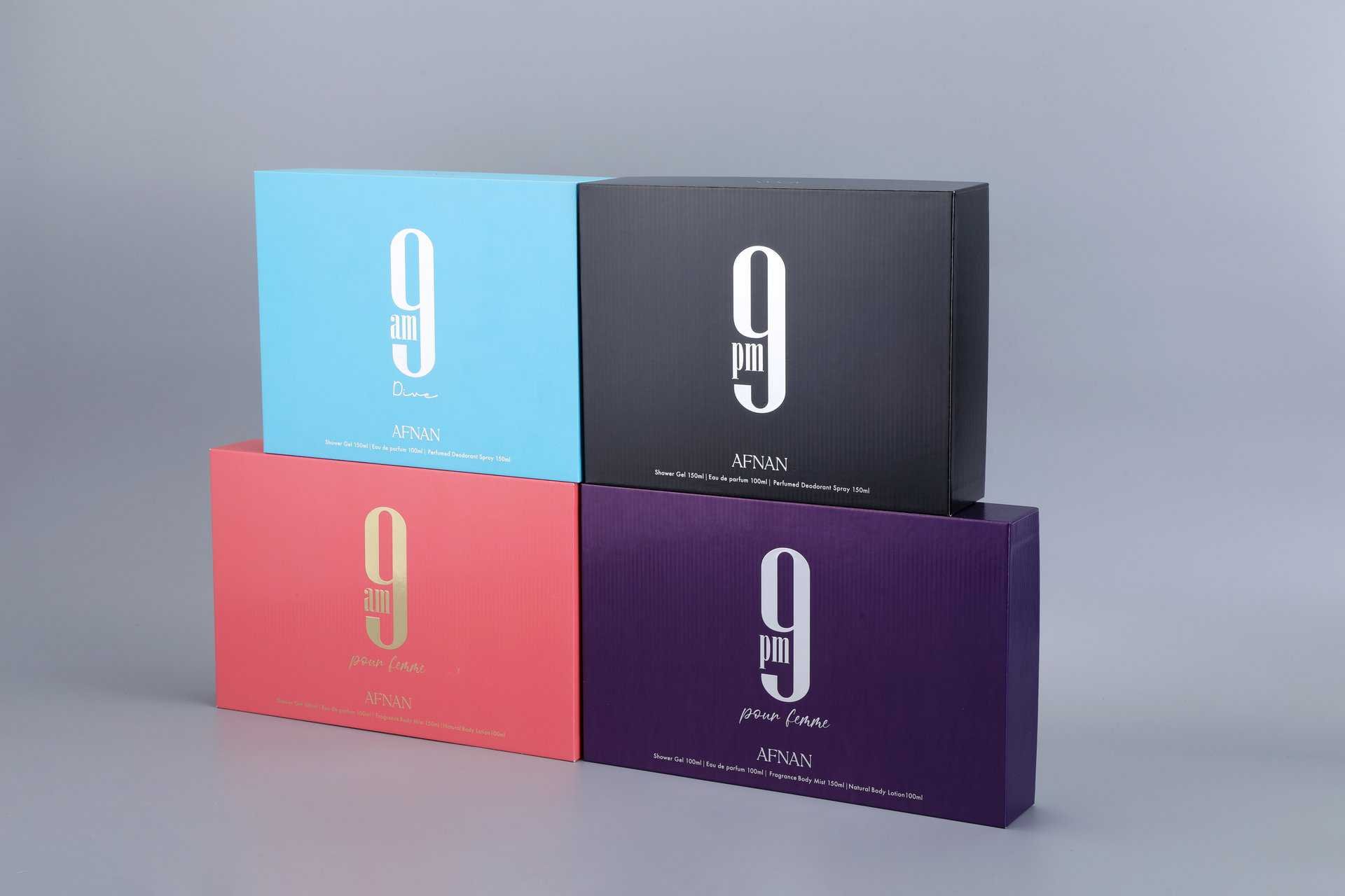 Four pastel-colored rectangular boxes are displayed on a neutral surface. Each box features a unique color: blue, black, pink, and purple. The design highlights their elegant and modern look suitable for various custom packaging needs.